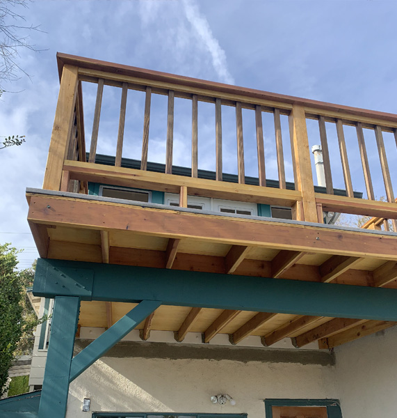 New deck installation with railing and stairs
