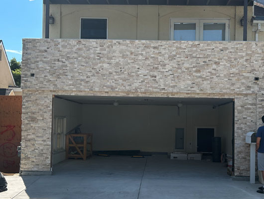 Custom stone veneer installation on modern home exterior