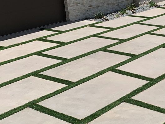 Exterior hardscape renovation project with concrete paver driveway construction and landscape detailing in Los Angeles