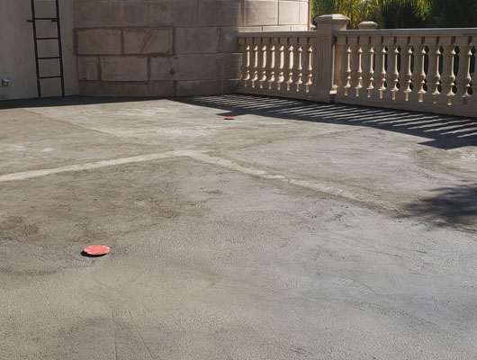 Hot mop waterproof membrane installation beneath exterior natural stone tile deck system in Beverly Hills
