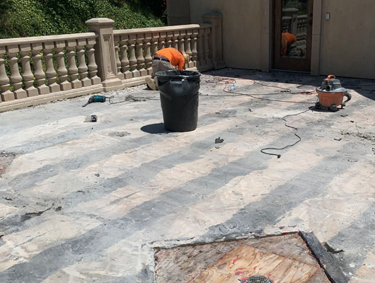 Exterior deck waterproofing and tile installation project featuring hot mop membrane and natural stone surfaces