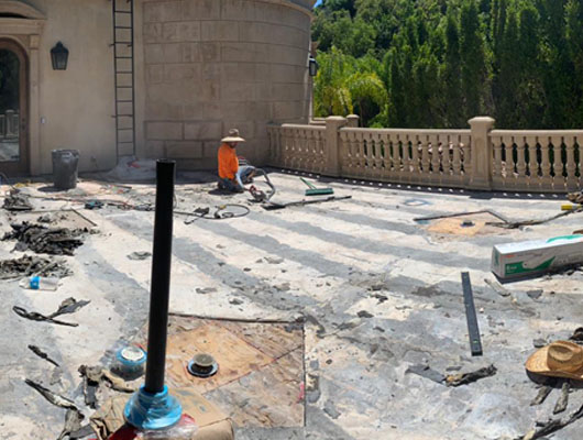 Natural stone exterior deck tile installation with hot mop waterproofing membrane and long-term moisture protection